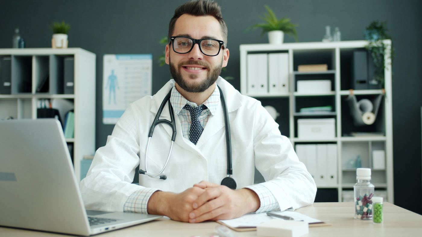 Smiling doctor with a stethoscope at a desk