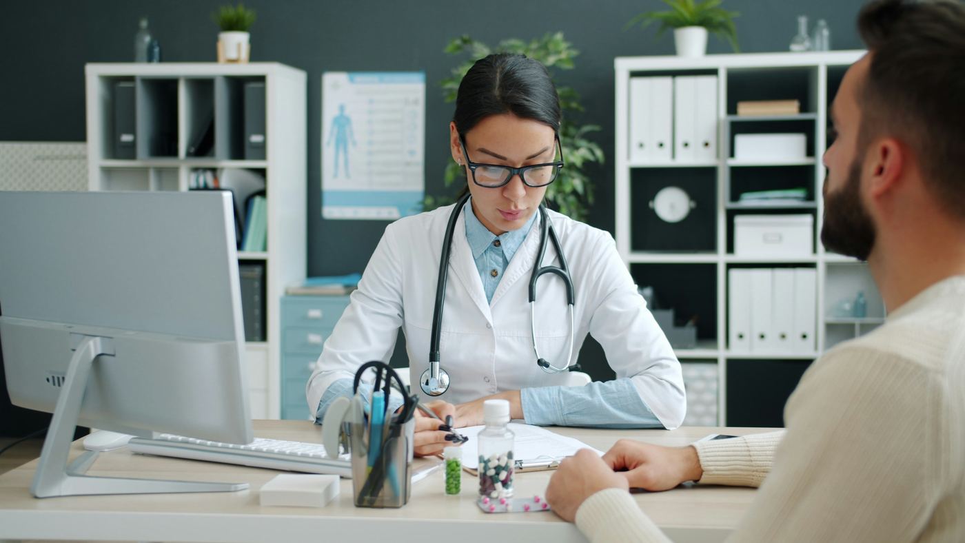 Doctor writing notes during a consultation